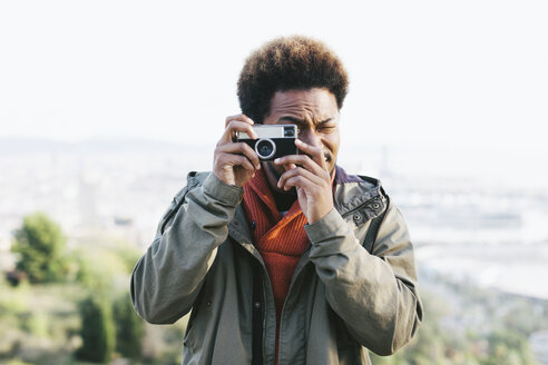 Portrait of young man taking a photo with old camera - EBSF001047