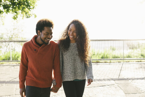 Portrait of happy young couple walking hand in hand - EBSF001070