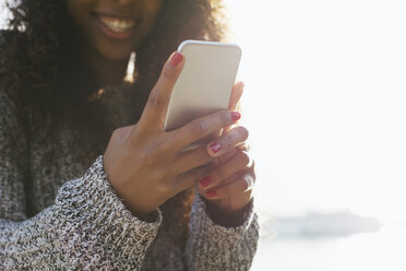 Hands of young woman holding smartphone - EBSF001076