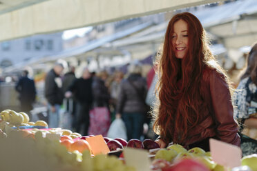 Lächelnde Frau auf dem Obstmarkt - GIOF000475