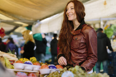 Lächelnde Frau auf dem Obstmarkt - GIOF000477