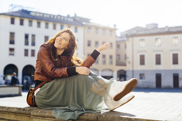 Italy, Padua, woman sitting outdoors at town square - GIOF000487