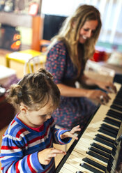 Frau und kleines Mädchen spielen zusammen Klavier - MGOF001048