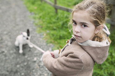 Porträt eines kleinen Mädchens mit ihrer französischen Bulldogge im Hintergrund - RAEF000656