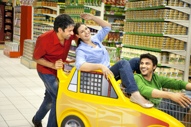 Drei Freunde, die zusammen in einem Supermarkt Spaß haben - RMAF000238