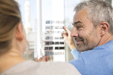 Paar zu Hause beim Betrachten alter Fotografien, lizenzfreies Stockfoto