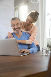 Ehepaar arbeitet zu Hause vom Laptop aus - FKF001585