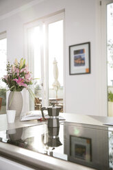 Blumenstrauß und Kaffeemaschine auf dem Ofen im Küchenblock - FKF001593