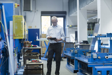 Mann mit digitalem Tablet in einer Werkstatt - SGF001963