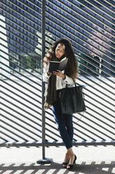 Junge Frau schreibt im Freien in ein Notizbuch - EBSF001104