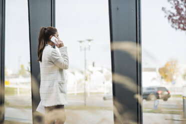 Young businesswoman outdoors talking on cell phone - UUF006063