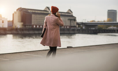 Junge Frau mit Handy am Flussufer - UUF006078