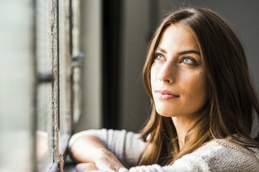 Brunette woman looking out of window - UUF006093