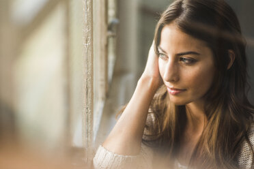 Brünette Frau schaut aus dem Fenster - UUF006094