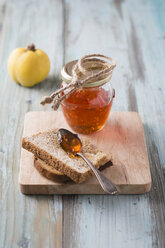 Quince jelly, slice of bread on chopping board - MYF001218