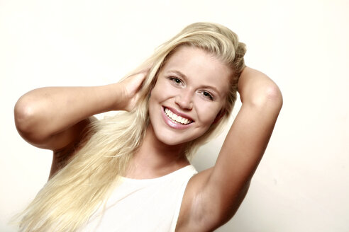 Portrait of smiling blond young woman with hands in her hair - VEF000057