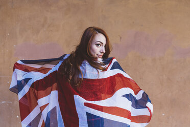 Lächelnde Frau, die eine britische Flagge hält - GIOF000534