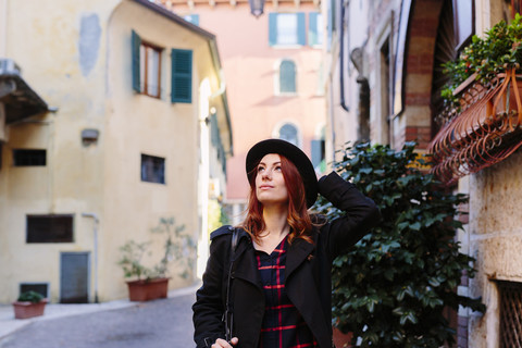 Italien, Verona, junge Frau in der Stadt, die sich umschaut, lizenzfreies Stockfoto
