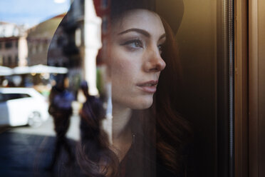 Pensive young woman window looking out of window - GIOF000542