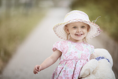Portrait of smiling blond little girl wearing hat and summer dress with floral design - NIF000055