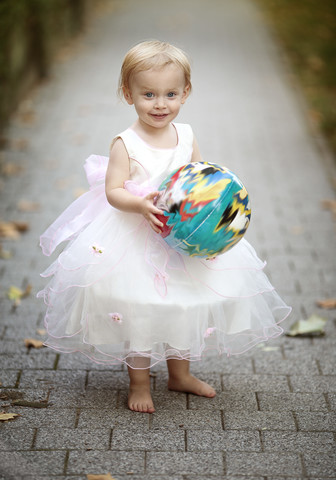 Porträt eines blonden kleinen Mädchens mit Ball im Tüllkleid, lizenzfreies Stockfoto