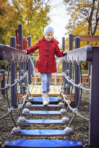 Mädchen läuft auf Brücke auf Spielplatz, lizenzfreies Stockfoto