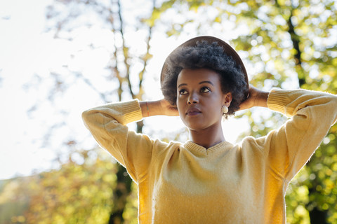 Schöne schwarze Frau mit Hut im Freien im Herbst, lizenzfreies Stockfoto