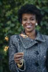 Beautiful black woman lighting sparklers outdoor - MAUF000015