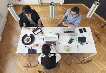 Drei kreative Geschäftsleute bei einer Besprechung in einem modernen Büro - JUBF000057
