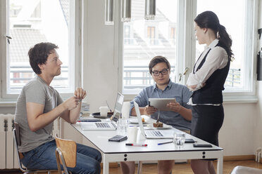 Drei kreative Geschäftsleute bei einer Besprechung in einem modernen Büro - JUBF000059