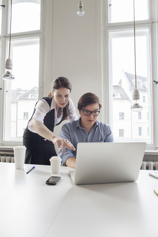 Zwei Kreativprofis arbeiten am Laptop, lizenzfreies Stockfoto