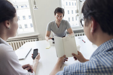 Drei kreative Geschäftsleute bei einer Besprechung in einem modernen Büro - JUBF000074