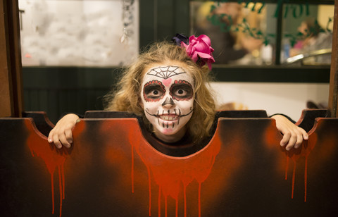 Blondes kleines Mädchen mit Zuckerschädel-Makeup an Halloween, lizenzfreies Stockfoto