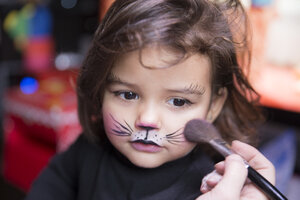 Frau malt das Gesicht eines kleinen Mädchens wie eine Katze - ERLF000080