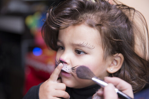 Woman painting little girl's face like a cat - ERLF000081