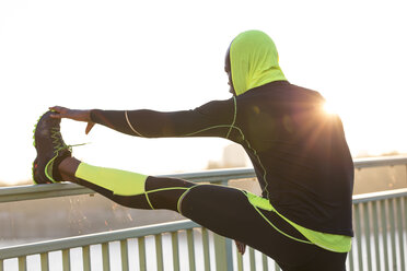 Athlete stretching on bridge railing - MADF000608