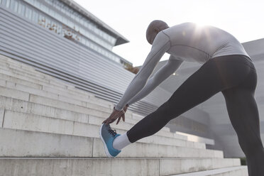 Athlete doing stretching exercises on stairs - MADF000616