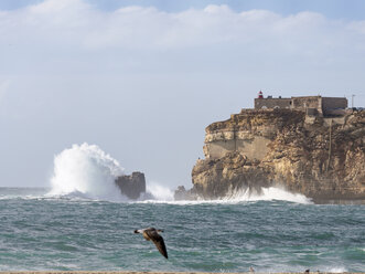 Portugal, Nazare, lighthouse and surf at rocky coast - LAF001567