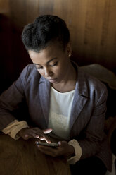 Young woman sitting in a cafe using smartphone - MAUF000026