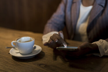 Junge Frau sitzt in einem Café und benutzt ein Phablet, Nahaufnahme - MAUF000031