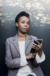 Portrait of pensive young woman with phablet - MAUF000034