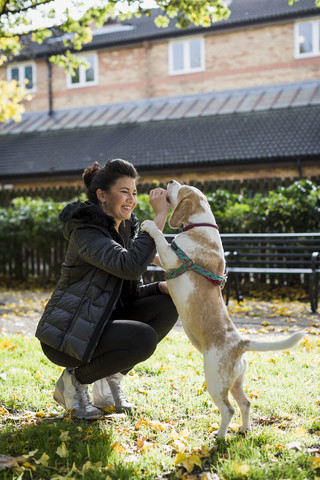 UK, London, Frau belohnt ihren Hund, lizenzfreies Stockfoto