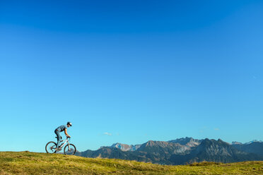 Germany, Bavaria, Fischen, mountainbiker on alpine meadow - HAMF000098