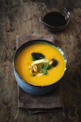 Bowl of vegan creamed pumpkin soup with walnuts and soy sauce - EVGF002524