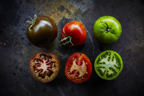 Schwarze, rote und grüne Tomate und drei Hälften, lizenzfreies Stockfoto