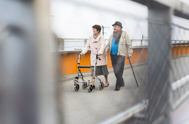 Älteres Paar, das mit Gehstock und Rollator unterwegs ist - UUF006136