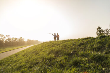 Senior couple walking with walking sticks in the nature - UUF006142