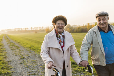 Lächelndes Seniorenpaar mit Rollator in der Natur - UUF006163