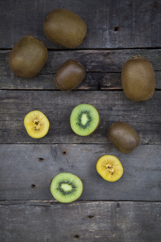 Grüne und goldene Kiwis auf Holz, lizenzfreies Stockfoto