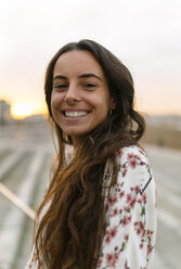 Portrait of smiling woman at evening twilight - MGOF001082